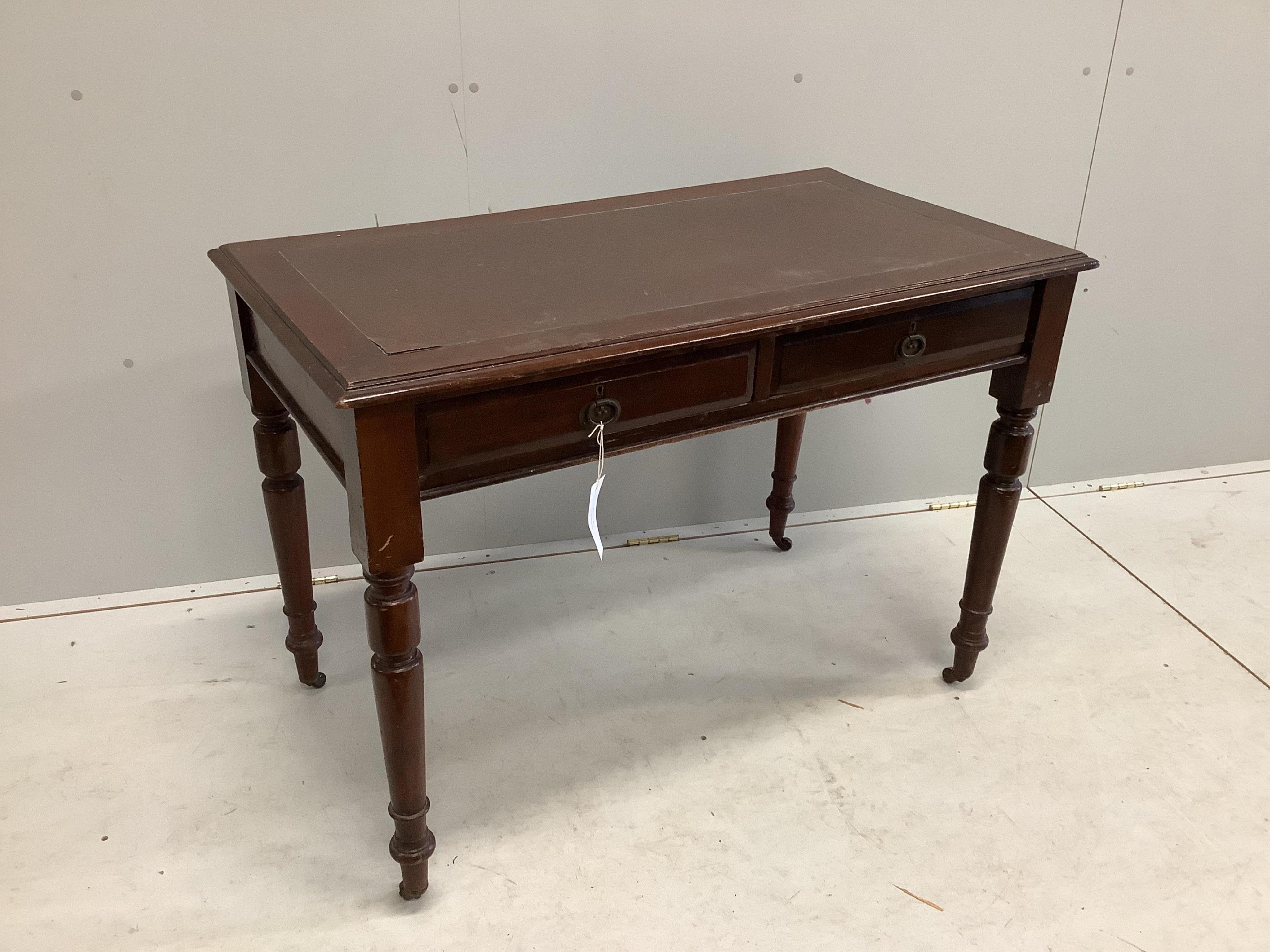 An early 20th century mahogany writing table with two frieze drawers with brass ring handles on turned legs and castors, width 106cm, depth 59cm, height 75cm. Condition - fair